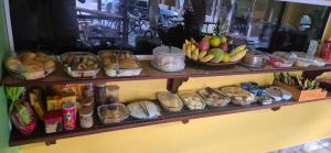 a shelf filled with bowls of fruit and other items at Pousada Recanto Sapoti in Barreirinhas