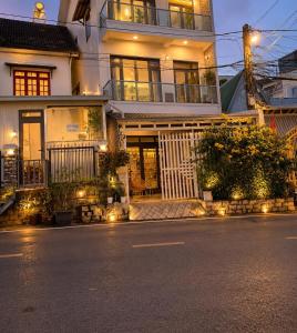 a large white house with lights on the street at La Maison DaLat Home in Ấp Kim Thạch