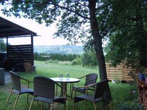 a table and chairs with drinks on it under a tree at Chalet de campagne LAJA only 5 min from autoroute A75 in Léotoing +19 photos