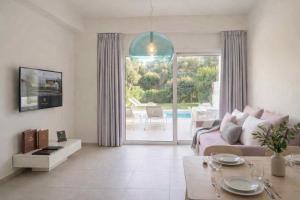 a living room with a couch and a table at Splash Suites with Private Pools in Nikiana