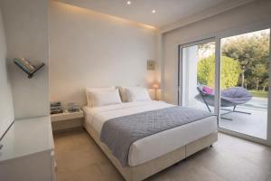 a bedroom with a bed and a sliding glass door at Splash Suites with Private Pools in Nikiana +35 photos