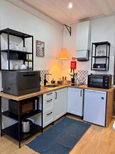 a kitchen with white cabinets and a counter top at Casinha do Solar in Angra do Heroísmo