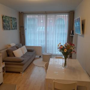 a living room with a couch and a table at Santhooft B , bus 514 Nieuwpoort bad in Nieuwpoort