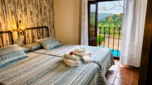 a bedroom with two beds with towels and a balcony at Cortijo Molino los Justos in Fuentes de Cesna +259 photos