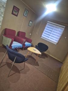 a room with chairs and a couch and a table at Cabaña Gazul in Porvenir