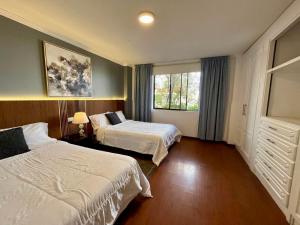 a hotel room with two beds and a window at Hospedaje en Quito Norte, Apartamento & Suite independientes in Quito