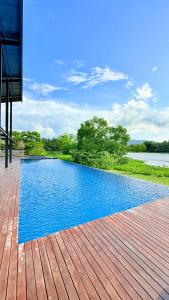 a swimming pool on a deck next to a body of water at Ceylon Elegance Villa in Kurunegala