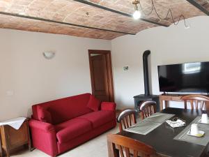 a living room with a red couch and a table at Le vigne in Asti