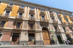 a large yellow building with lots of windows at L'AFFACCIO in Catania