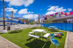 a park with picnic tables and a peacock on the grass at Travelsuites Hotel in Las Vegas