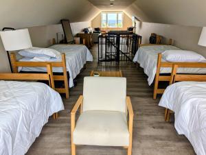 a room with four beds and two chairs at Scenic Homestead Barndominium in Dryden