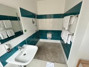 ein Badezimmer mit Waschbecken und Dusche in Blau und Weiß in der Unterkunft Hôtel Carmin in Le Havre