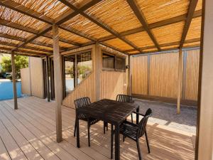 a wooden patio with a table and chairs on a deck at Simos Camping Elafonisos Tents & Bungalows in Elafonisos