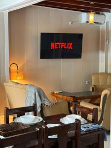 a netflix sign on a wall with tables and chairs at Chalet duplex N 7 avec piscine in Bouzareah +15 photos