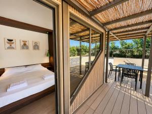 a balcony with a bed and a table on a deck at Simos Camping Elafonisos Tents & Bungalows in Elafonisos +62 photos