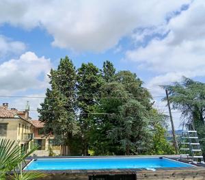 a swimming pool in front of some trees at Le vigne in Asti