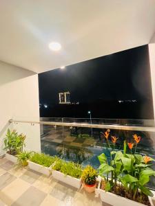 a large flat screen tv on a balcony with plants at VyVy House Hotel in Tuy Hoa