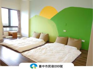 two beds in a room with a green and yellow wall at Sun Moon Star in Xinshe