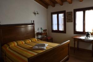 1 dormitorio con 1 cama con 2 toallas en Ca Borgh, en Santa Maria di Feletto