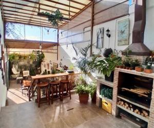 a large room with a bar with chairs and plants at Hospedaje en Quito Norte, Apartamento & Suite independientes in Quito