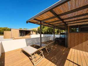 a patio with a wooden deck with awning at Simos Camping Elafonisos Tents & Bungalows in Elafonisos