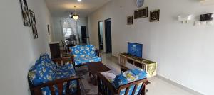 a living room with blue chairs and a television at Homestay Cikgu 2 Hospital Kuala Krai in Kuala Kerai