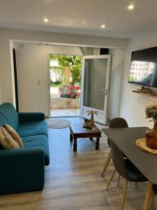 a living room with a blue couch and a table at Charmant appartement à Ajaccio in Ajaccio