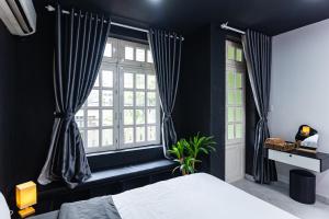 a bedroom with black walls and a bed and a window at Four P Home - Binh Thanh in Ho Chi Minh City