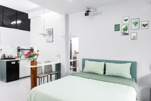 a white bedroom with a bed and a kitchen at Four P Home - Binh Thanh in Ho Chi Minh City