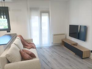 a living room with a couch and a flat screen tv at El Loft de Cris in Béjar
