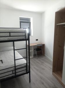 a room with two bunk beds and a desk at El Loft de Cris in Béjar