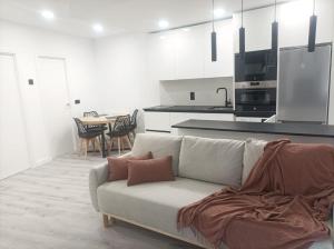 a living room with a couch and a kitchen at El Loft de Cris in Béjar
