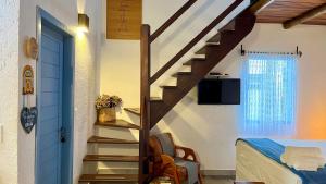 a staircase leading up to a bedroom with a bed and a room at Chalés Calima in Lençóis