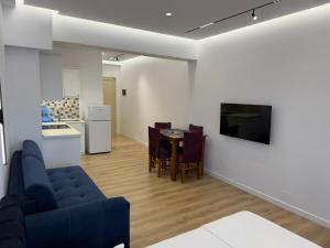 a living room with a blue couch and a table at Rei Apartments in Sarandë