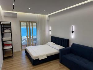 a bedroom with a bed and a blue couch at Rei Apartments in Sarandë