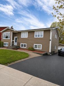 a house with a car parked in a driveway at Excellence vacation home in St. John's