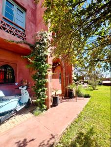 a scooter parked in front of a house at Serene Villa with 4 Pools, Palmeraie, Marrakech in Douar Soukkane