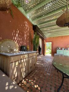an outdoor kitchen with a counter and a table at Serene Villa with 4 Pools, Palmeraie, Marrakech in Douar Soukkane