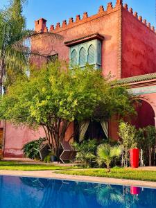 a house with a swimming pool in front of it at Serene Villa with 4 Pools, Palmeraie, Marrakech in Douar Soukkane