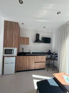a kitchen with wooden cabinets and a white appliance at Quercus in Pozoblanco +8 photos