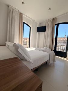 a bedroom with two beds and a large window at Quercus in Pozoblanco
