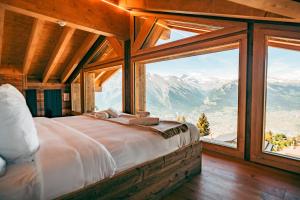 a bedroom with a bed with a view of mountains at Nînda Boutique Hôtel in Nendaz