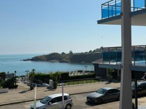 two cars parked in a parking lot next to the ocean at ESKADA Apartments in Ahtopol