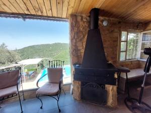 a fireplace in a room with two chairs and a window at Havana chalet in Jrabtā
