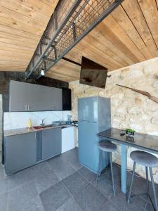 a kitchen with a refrigerator and a table with stools at Havana chalet in Jrabtā