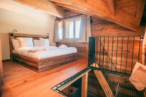 a bedroom with a bed in a room with wooden floors at Nînda Boutique Hôtel in Nendaz
