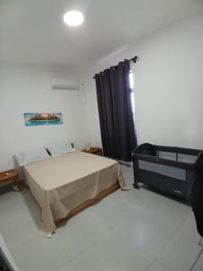 a bedroom with a bed and a black curtain at Acacia Residences in Post of Flacq