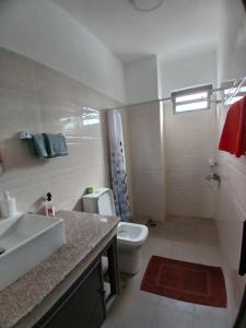 a bathroom with a white toilet and a sink at Acacia Residences in Post of Flacq