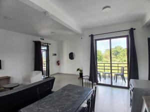 a living room with a table and a large window at Acacia Residences in Post of Flacq