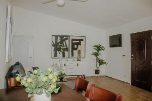 a dining room with a table with a vase of flowers at Villa La Dueña Las Terrenas in Las Terrenas